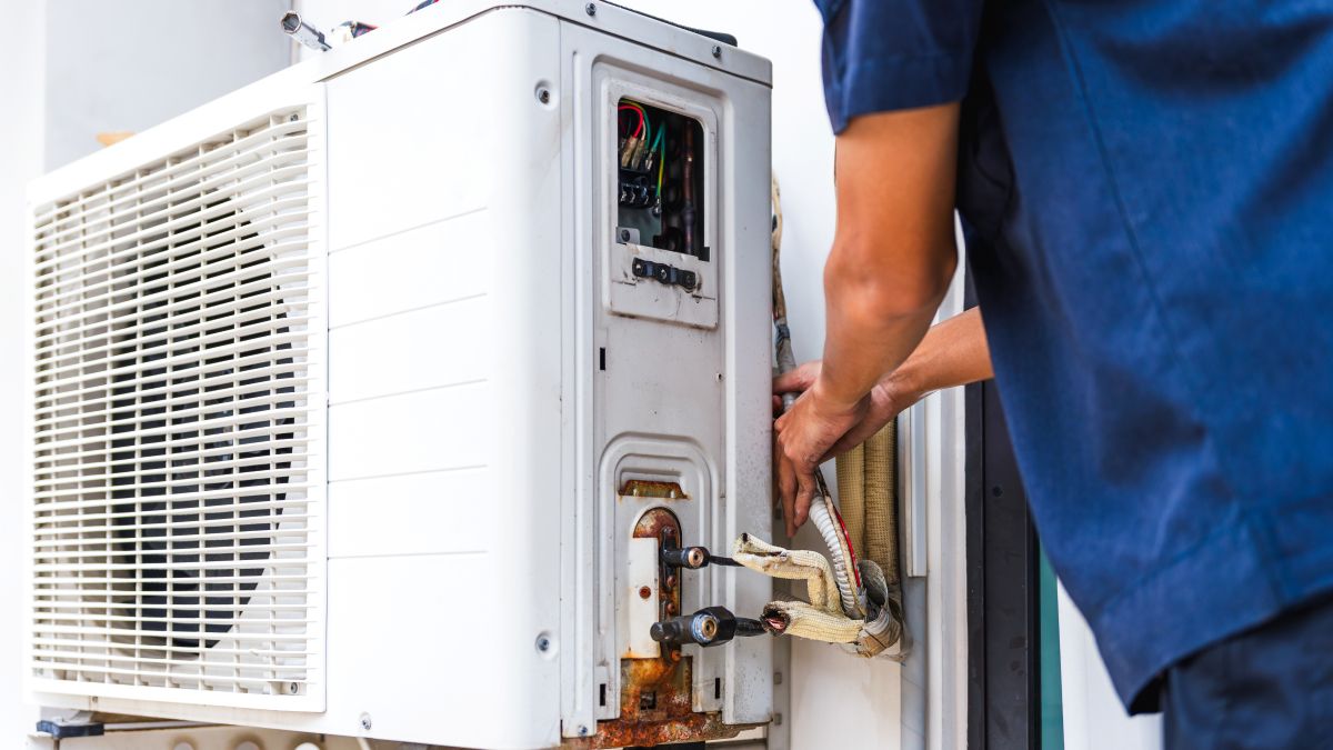 HVAC Technician Fixing an Outdoor Air Conditioning Unit